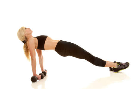 A woman lifting her back up with her hands on weights.の写真素材