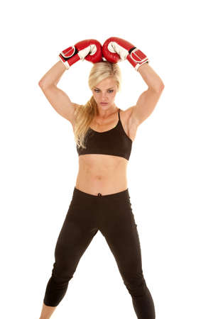 A woman standing with her boxing gloves on her head.の写真素材