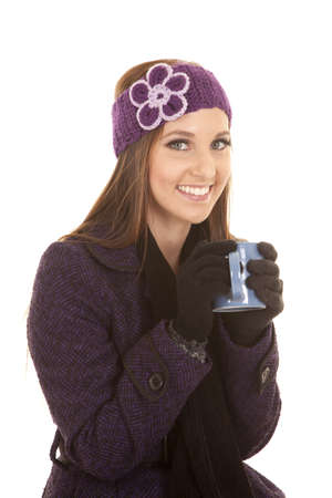 A woman holding on to a mug with a smile on her face.の写真素材