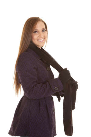 a woman in her winter coat and scarf with a smile on her lips.の写真素材