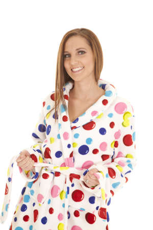 A woman in her polka dot robe with a smile on her face.の写真素材