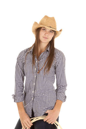 A woman in her cowgirl hat holding on to a ropeの写真素材