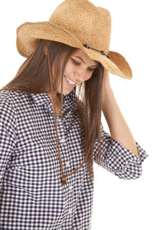 a woman in her cowgirl hat looking down with a smile on her lips.の写真素材