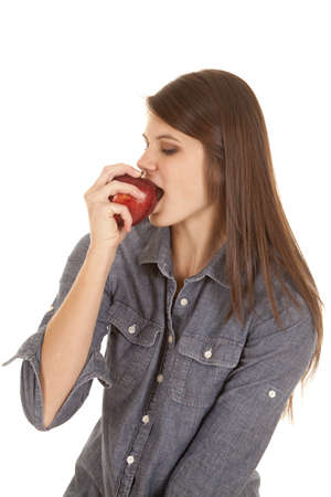 a woman getting ready to dig her teeth in to an apple.の写真素材