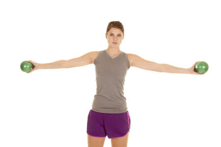 A woman working out with weighted green balls with a serious expression on her faceの写真素材