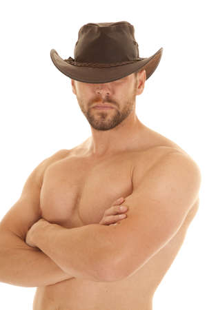 A cowboy without a shirt on and with his brown cowboy hat on.の写真素材