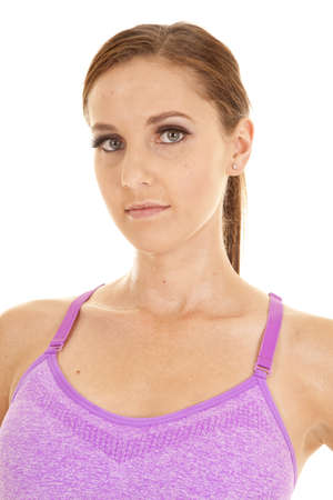 A close up of a woman in her purple sports bra with a serious expression on her face.の写真素材