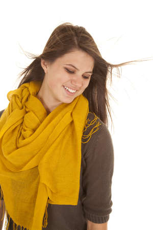 a woman looking down smiling as the wind is blowing her hair.の写真素材