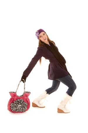 A woman with a funny expression dragging her purse behind her because it is heavy.の写真素材