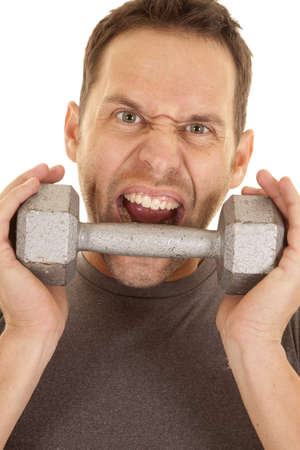 a close up of a man's face with a crazy expression on his face getting ready to bite a weight.の写真素材