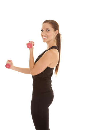 A woman working out with her weights with a smile on her face.の写真素材