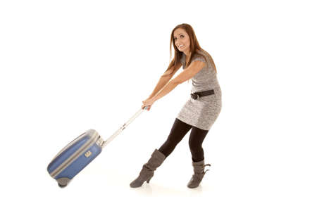a woman trying really hard to pull her suitcase.の写真素材