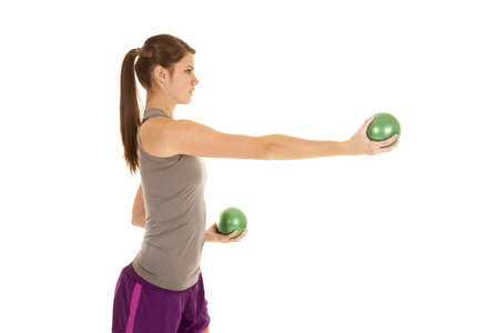 A woman working out by using her green weighted balls.の写真素材