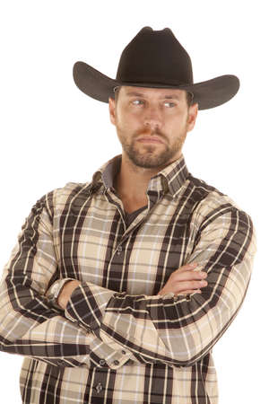 A man in his plaid shirt and black western hat with a serious expression on his face.の写真素材