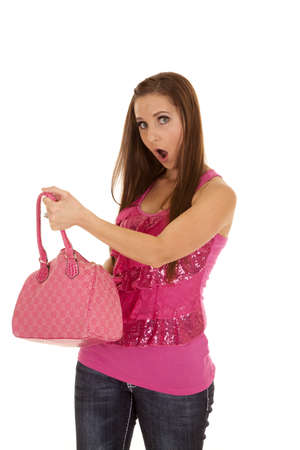 A woman looking into her pink purse with a shocked expression on her face.の写真素材