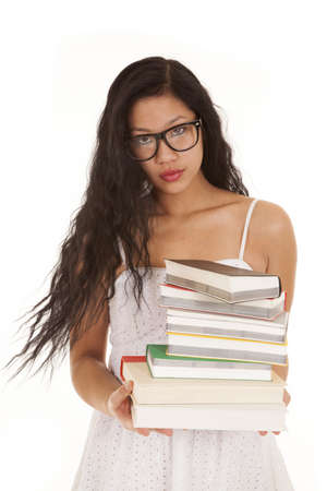 A Asian student holding on to her stack of books wearing her glasses.の写真素材