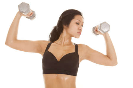an woman working out lifting weights with a serious expression on her face.の写真素材