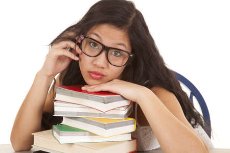 An Asian woman with her head on a stack of books.の写真素材