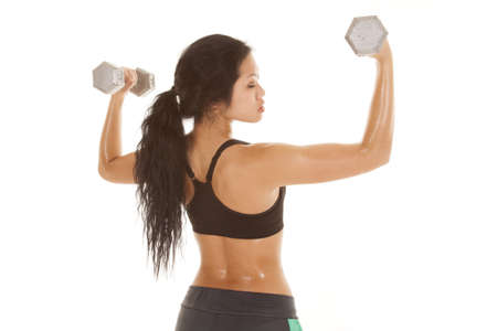 A woman dripping with sweat working out with weights.の写真素材