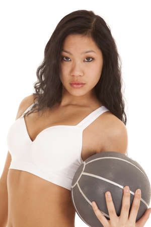 A woman holding on to a weighted medicine ball with a serious expression.の写真素材