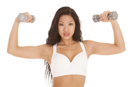A woman showing off her arms by flexing and using weights.の写真素材