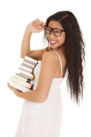 A woman with a stack of books in her arms with a smile on her face.の写真素材