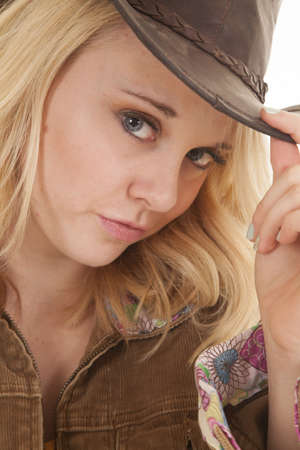 a close up of a woman holding on to the brim of her cowgirl hat.の写真素材