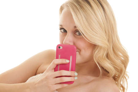 A woman with a phone covering her smile.の写真素材