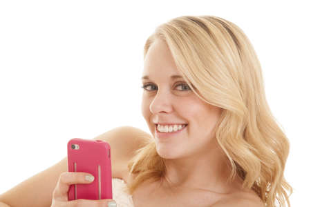 A woman holding on to her cell phone up by her face smiling.の写真素材