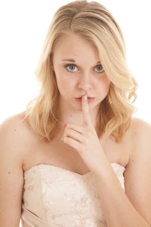 A woman in her fancy dress with her finger up to her lips telling you to be quiet.の写真素材