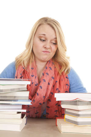 A woman looking down at the stacks of books not sure where to start.の写真素材