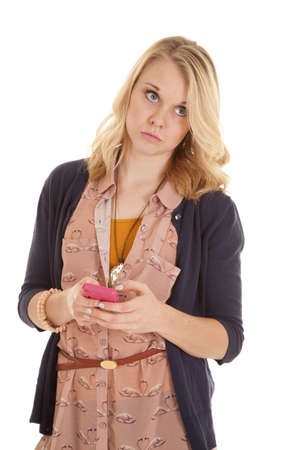A woman texting on her phone looking away with an unhappy expression on her face.の写真素材