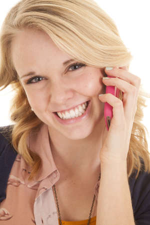a woman talking on the phone with a big smile on her face.の写真素材