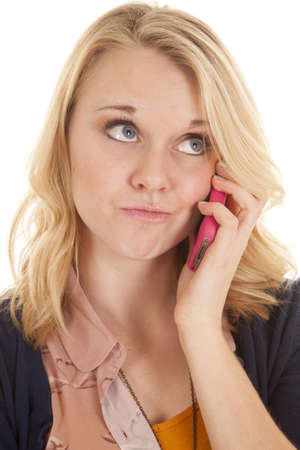 A woman with a smirk on her face listening to someone on the phone.の写真素材