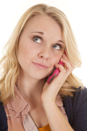 A woman talking on the phone with a small smile on her lips.の写真素材