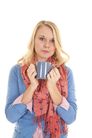 A woman holding on to he blue mug with a small smile on her lips.の写真素材