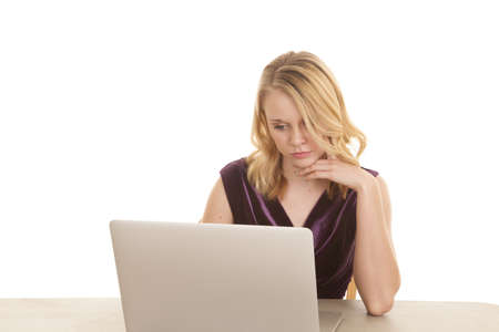 A woman working hard by working on her laptop with a thoughtful expression on her face.の写真素材