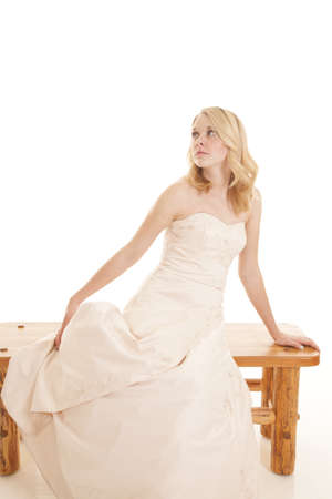 A woman sitting on a bench in her formal gown.の写真素材