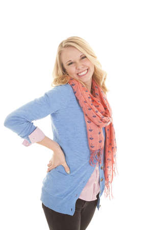 a woman with a big smile on her face in her blue sweater and pink scarf.の写真素材