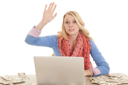 A woman raising her hand to ask a question on her laptop with money all around her.の写真素材
