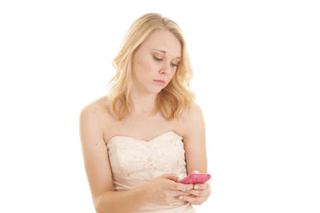 A woman with a sad expression looking down at her phone.の写真素材