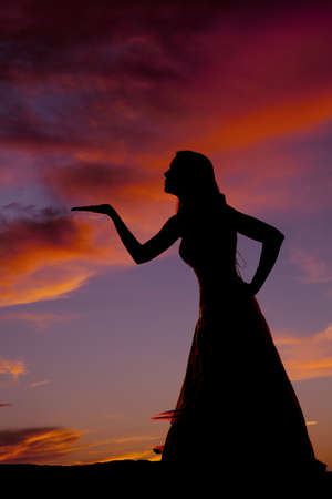 a silhouette of a woman blowing a kiss out into the nightの写真素材