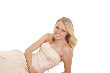 A woman in her formal dress with a smile on her lips, leaning back.の写真素材