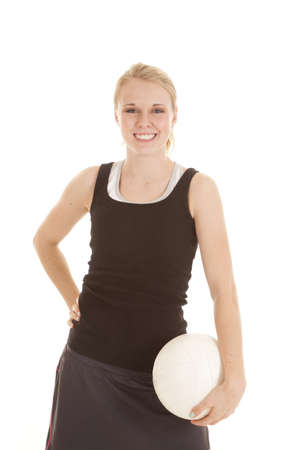 A woman with a big smile on her face holding on to her volleyball.の写真素材