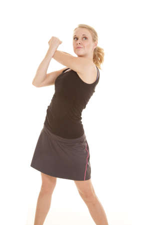 A woman with a small smile on her lips stretching out her arm.の写真素材