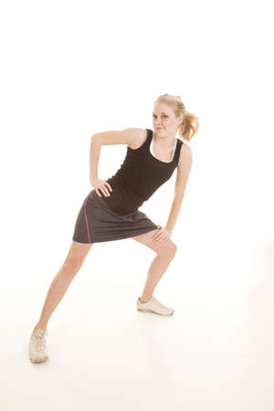 A woman stretching her legs out with a small smile on her face.の写真素材