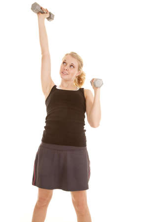 a woman with a small smile on her face as she lifts her weight high up in the air.の写真素材