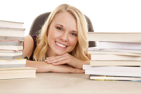 a woman with a big smile on her face with it between two stacks of books.の写真素材