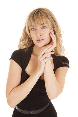 A woman in her black top with her hand resting on her cheek.の写真素材