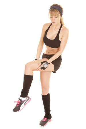 a woman in her fitness attire holding on to her leg to stretch.の写真素材